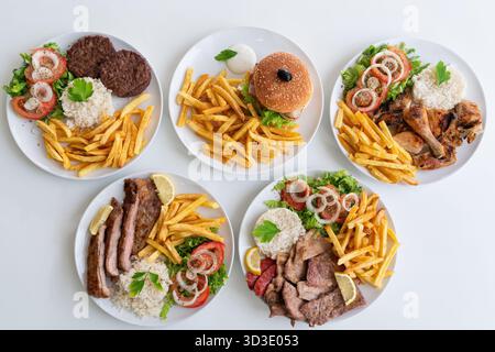 Assortimento vario di piatti alla griglia, assortimento di piatti alla griglia con accompagnamenti di verdure, varietà di piatti alla griglia serviti con patatine fritte croccanti e. Foto Stock