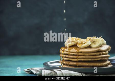 Versare sciroppo d'acero sulla pila di pancake, copiare l'immagine dello spazio Foto Stock