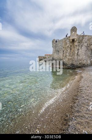 Budva, Montenegro - Aprile 2018 : la gente seduta sulla sommità di alte mura della città vecchia di fort Foto Stock
