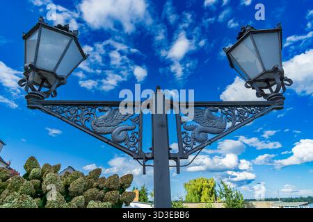 Una dettagliata vista verso l'alto di una storica lanterna in ferro battuto situata nella città vecchia di Werder (Havel), Brandeburgo. L'elegante maestria artigianale, fe Foto Stock