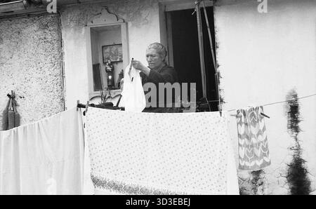 Roccagorga, Italia, 1982. Donna del posto che appende il bucato su una stoffa da un balcone. Foto Stock