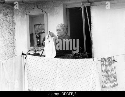 Roccagorga, Italia, 1982. Donna del posto che appende il bucato su una stoffa da un balcone. Foto Stock
