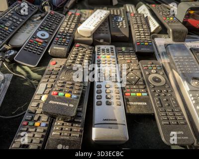 SABAC, SERBIA - 20 SETTEMBRE 2025: Telecomandi TV usati messi in vendita in un mercato delle pulci di Sabac. Marchi e modelli misti riempiono la tabella, in se Foto Stock
