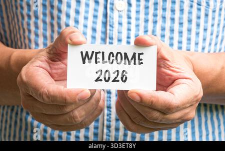 Primo piano di un uomo con un cartellino bianco con Welcome 2026 Foto Stock