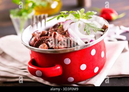 funghi commestibili con cipolla in un recipiente di metallo Foto Stock