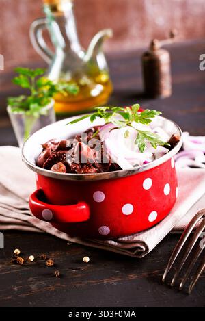 funghi commestibili con cipolla in un recipiente di metallo Foto Stock