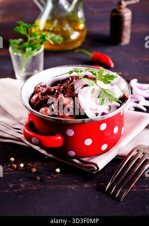 funghi commestibili con cipolla in un recipiente di metallo Foto Stock