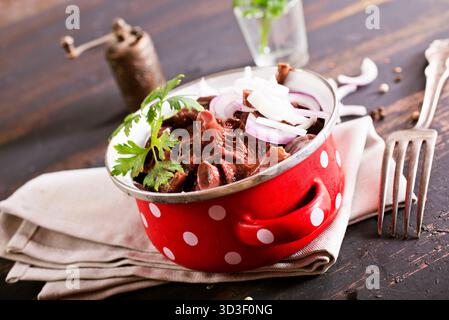 funghi commestibili con cipolla in un recipiente di metallo Foto Stock