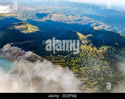 Vista aerea della scogliera rocciosa del vulcano Kawah Ijen con lago d'acqua turchese e zolfo all'alba. Incredibile vista del paesaggio naturale a Giava orientale, Indonesia. Natu Foto Stock