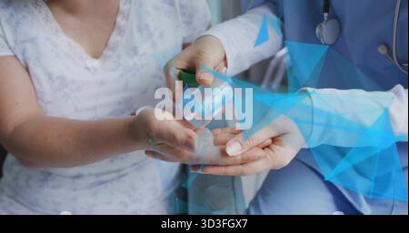 Medico in scrub dispensa pillole nel palmo del paziente nella sala esame, con stetoscopio e flacone per pillole Foto Stock