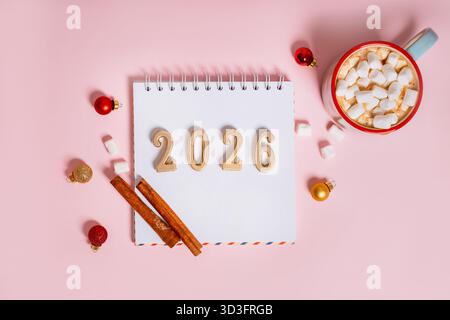 L'appartamento festivo si stendeva su un tema natalizio con figure per l'anno 2026 e decorazioni e cacao su sfondo isolato Foto Stock