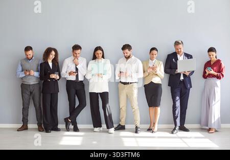 Gruppo aziendale che lavora online con telefoni e laptop Foto Stock