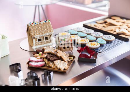 Dolci a tema natalizio, tra cui case di pan di zenzero e biscotti decorati, presentati su un tavolo in una casa a Quito, Ecuador. Prelibatezze natalizie Foto Stock