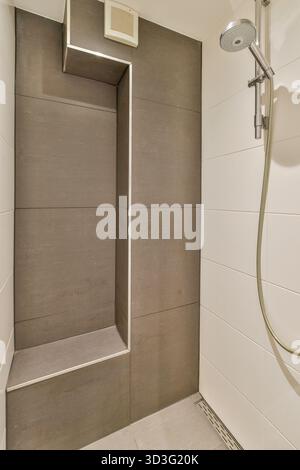 Una doccia elegante e contemporanea con elementi di design minimalista e una disposizione spaziosa, perfetta per le case moderne. Foto Stock
