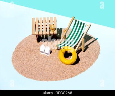 Un ambiente da spiaggia minimalista con una sedia a sdraio bianca e verde a righe sulla sabbia, un tavolo in legno, sandali bianchi e un anello gonfiabile giallo sotto un luminoso Foto Stock