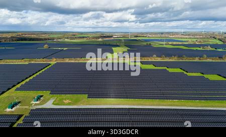 Vista aerea dei pannelli solari che si crogiolano sotto un cielo nuvoloso vicino a campi verdi, in netto contrasto con il paesaggio industriale di Mansfield, Inghilterra, Unite Foto Stock