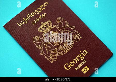 Libretto dei passaporti georgiani su sfondo di carta blu chiaro primo piano. Documento di viaggio su superficie blu Foto Stock