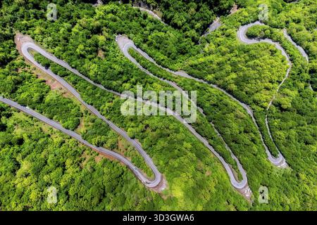 Vista aerea di una strada tortuosa che serpeggia attraverso fitte foreste verdi, creando un contrasto sorprendente tra natura e infrastrutture, Ramian, Golestan Pr Foto Stock