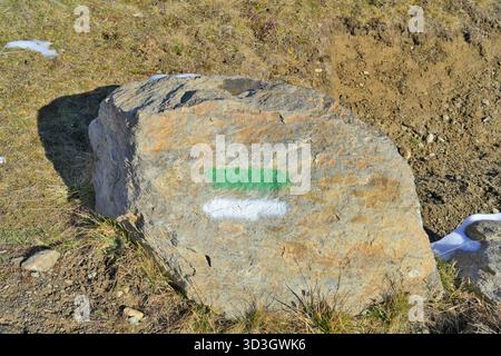 Segnavia di montagna dipinto di verde e bianco sulla roccia. Roccia con una striscia verde e bianca dipinta che indica un sentiero escursionistico. Foto Stock