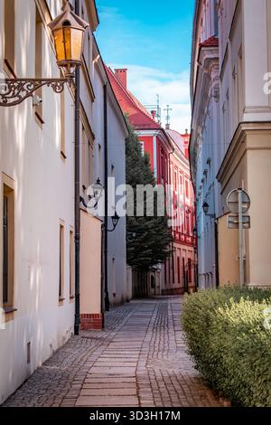Una strada stretta, pulita e bella nella città vecchia di Wroclaw con case luminose e lampioni. Foto Stock