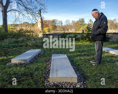 6 novembre 2025, Brandeburgo, Fürstenberg/Havel: Berl Katznelson si trova dietro la pietra per sua madre Karen Katznelson al Memoriale di Ravensbrück dopo la scoperta delle pietre commemorative. Il memoriale, costituito da 40 blocchi di pietra incisi, è destinato a commemorare circa 20.000 donne, uomini e bambini ebrei che furono imprigionati nel campo di concentramento femminile di Ravensbrück tra il 1939 e il 1945. Suo fratello maggiore, l'ebreo danese Ib Katznelson, fu deportato a Ravensbrück con sua madre da bambino nel 1943. Foto: Soeren Stache/dpa Foto Stock