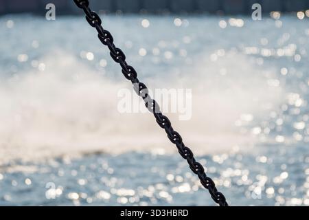 Una catena sullo sfondo di acqua frizzante. Primo piano. Foto Stock