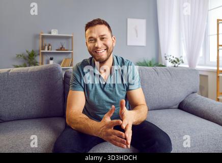 Happy Man che si rilassa sul divano di casa Foto Stock