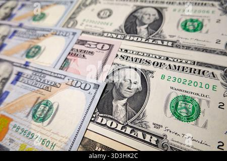 In questa illustrazione fotografica, una composizione di varie banconote statunitensi, tra cui banconote da 100, 50 e 1 dollaro, disposte per mostrare tagli diversi. Foto Stock