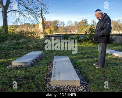 6 novembre 2025, Brandeburgo, Fürstenberg/Havel: Berl Katznelson si trova dietro la pietra per sua madre Karen Katznelson al Memoriale di Ravensbrück dopo la scoperta delle pietre commemorative. Il memoriale, costituito da 40 blocchi di pietra incisi, è destinato a commemorare circa 20.000 donne, uomini e bambini ebrei che furono imprigionati nel campo di concentramento femminile di Ravensbrück tra il 1939 e il 1945. Suo fratello maggiore, l'ebreo danese Ib Katznelson, fu deportato a Ravensbrück con sua madre da bambino nel 1943. Foto: Soeren Stache/dpa Foto Stock