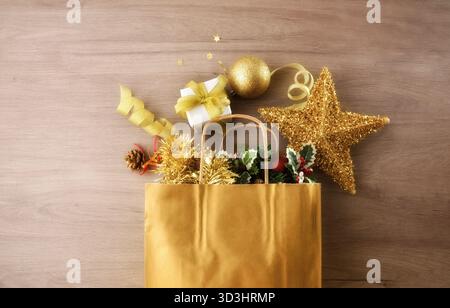 Concetto regalo di Natale con una borsa piena di regali e decorazioni natalizie su un tavolo di legno. Vista dall'alto. Foto Stock