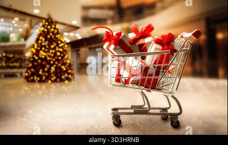 Concetto di shopping da regalo natalizio con carrello pieno di pacchetti regalo confezionati in carta bianca e nastro rosso nel centro commerciale. Foto Stock