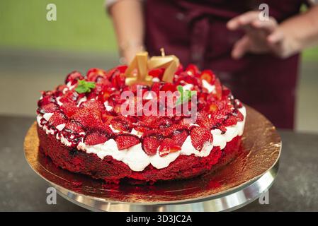 Cibo, torta alle fragole festiva con panna montata e frutti di bosco freschi, decorata con candele dorate per festeggiare il 47° compleanno Foto Stock