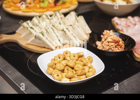 Cibo, antipasti italiani assortiti tra cui taralli, panini cremosi e affettati serviti su un tavolo a buffet per aperitivo o festa Foto Stock