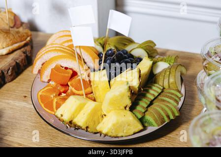 Cibo, vivace assortimento di frutta fresca a fette, tra cui ananas, kiwi, pera, uva e agrumi su un piatto da portata in occasione di un evento Foto Stock