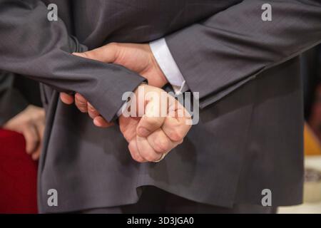 Uomo d'affari che nasconde il pugno alle spalle Foto Stock