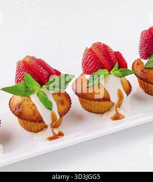 Cibo, cupcake alla vaniglia con fragole su piatto bianco Foto Stock