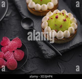 Cibo, fetta di torta matcha con vaniglia e lamponi Foto Stock