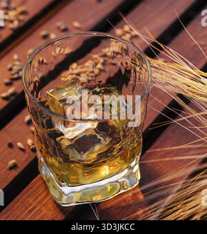 Cibo, Un bicchiere di whisky in un campo di grano Foto Stock