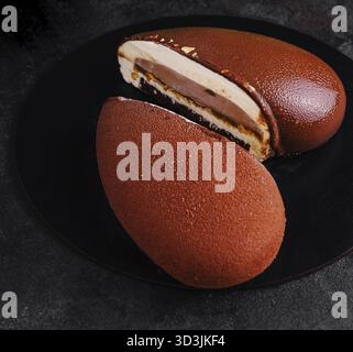 Cibo, Mousse Cake Snickers su piatto nero Foto Stock