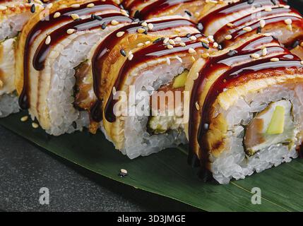 Cibo, sushi Set canada Roll con anguilla su pietra nera Foto Stock