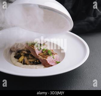 Cibo squisito, serve medaglioni di manzo con funghi e purè di patate Foto Stock