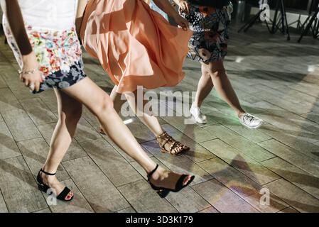 Anno nuovo, celebrazione, discoteca concetto - donne in abiti da sera in ballo nel club, parte del corpo gambe femmina in tacchi alti sul pavimento di partito Foto Stock