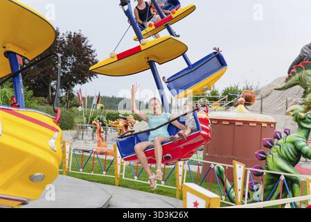 Loifling, Germania - 26 luglio 2018: Mamma e sua figlia si divertono sulla giostra Star Fly nel parco divertimenti Churpfalzpark Loifling Foto Stock