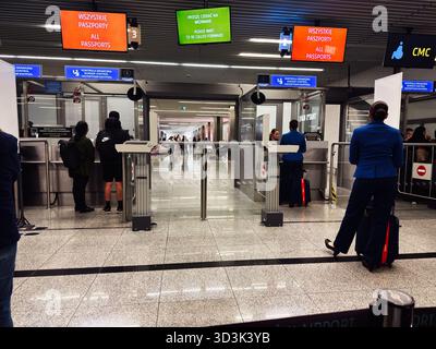 Balice, Polonia - 4 ottobre 2025: I viaggiatori fanno la fila al controllo di frontiera a Cracovia, Polonia, mentre il personale controlla i controlli dei passaporti e la segnaletica. Foto Stock