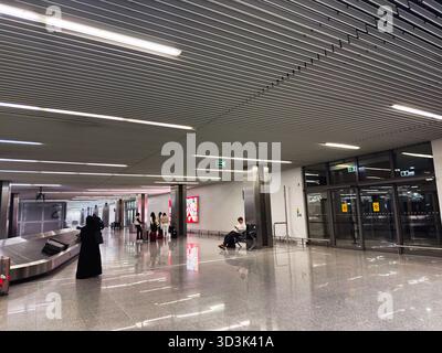 Balice, Polonia - 4 ottobre 2025: Spazioso terminal dell'aeroporto di Cracovia con i viaggiatori in attesa accanto alla giostra dei bagagli e ai posti a sedere. Foto Stock