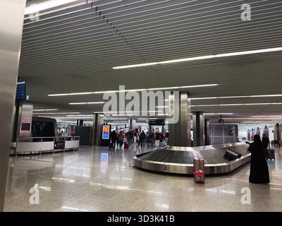 Balice, Polonia - 4 ottobre 2025: L'affollato aeroporto di Cracovia mostra i bagagli su una cintura in movimento tra i viaggiatori. Foto Stock