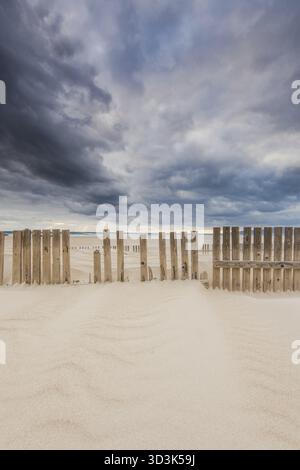 Recinzione di legno sulle dune e spiaggia in caso di tempesta a Tarifa, Spagna Foto Stock