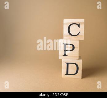 Tre blocchi di legno impilati uno sopra l'altro con le lettere CPD. Sviluppo professionale continuo Foto Stock