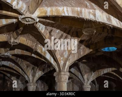 Dettaglio ravvicinato del soffitto di una cisterna storica vuota con resti di sedimenti di depositi d'acqua Foto Stock