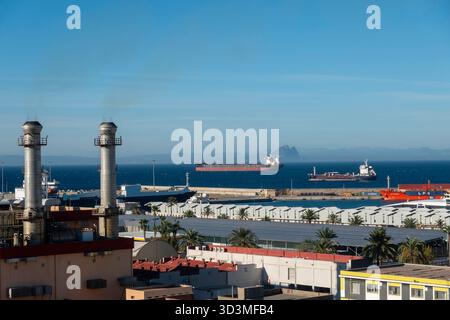 Ceuta, Spagna - 24 ottobre 2025: Navi che navigano nello stretto di Gibilterra viste da Ceuta, una città spagnola del Nord Africa, con la Rocca di Gibilterra Foto Stock
